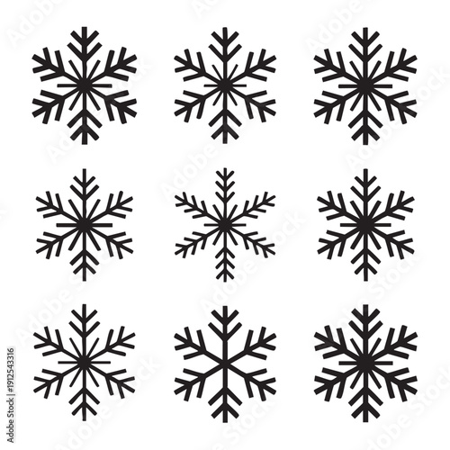 Collection of black snowflakes arranged in a grid pattern on a white background viewed from directly above