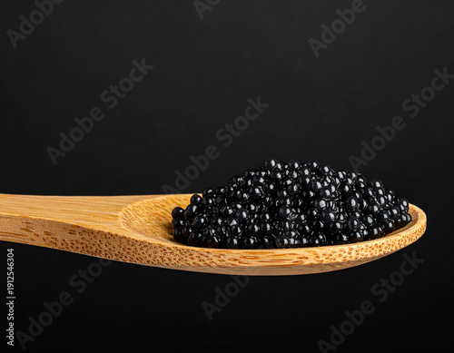 Black Caviar on a Wooden Spoon, Gourmet Sturgeon Roe Delicacy on Black Background