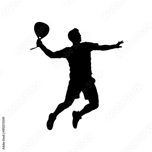 Silhouette of a man playing badminton, jumping and hitting the shuttlecock