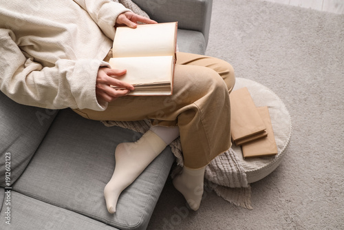 Young woman reading book on...