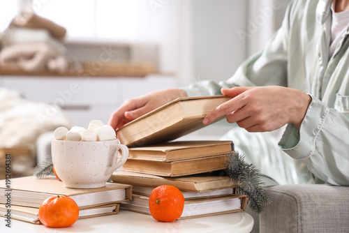 Young woman taking book fro...