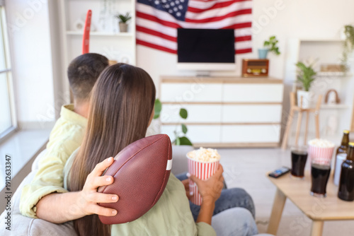 Young couple with popcorn w...