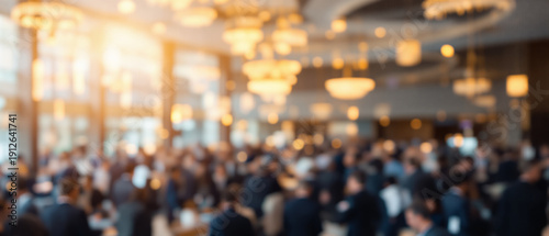 Blurred motion of large crowd attending business conference in modern hall. Defocused abstract background of corporate event networking, audience gathering in hotel lobby and busy exhibition center.