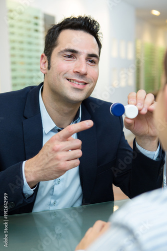 man pointing at lenses in optics