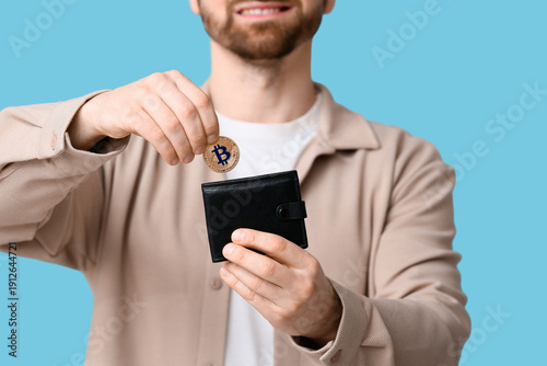 Young man putting bitcoin i...