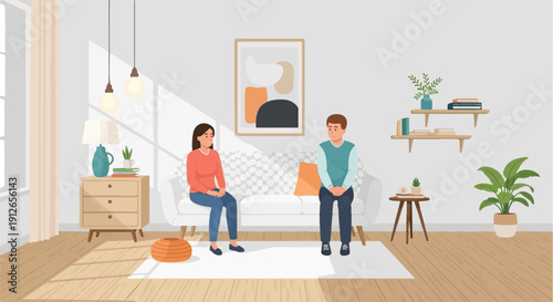 Two people sit on a sofa in a sunlit living room