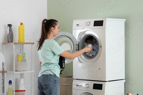 Young woman doing laundry i...