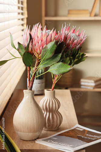 Vases with protea flowers a...