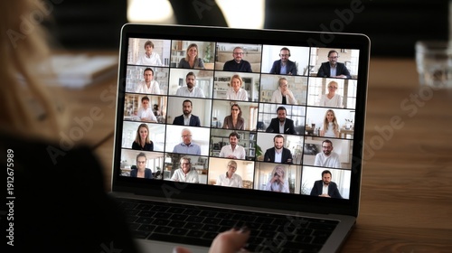 Laptop Screen Displaying a Virtual Meeting with Many Participants.