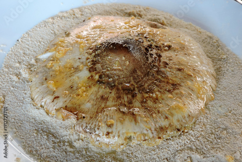 Wallpaper Mural Preparing a parasol mushroom schnitzel: a mushroom cap with breadcrumbs on a plate Torontodigital.ca