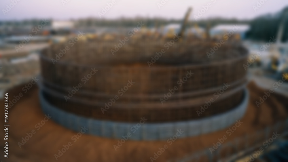 Fototapeta premium Blurred background of Large diameter bored pile cage prefabrication on ground surface, cylindrical reinforcement cage with spiral ties and longitudinal bars extending over.