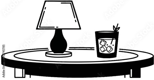 A lamp and a drink with ice cubes sit on a round table