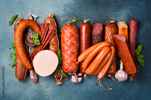 Different types of tasty sausages on grey table, flat lay