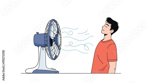 Young man standing in front of an electric table fan to cool down and get relief from the summer heat with a pleasant breeze.