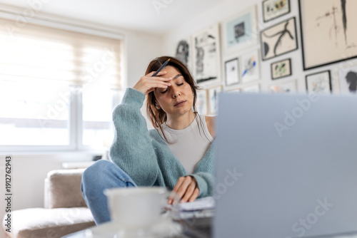 Tableau sur toile Stressed businesswoman with eyes closed touching forehead while working on laptop
