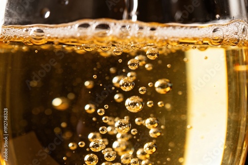 Macro shot of golden champagne bubbles rising and bursting in a glass, creating a frothy head with a sparkling, celebratory atmosphere, perfect for festive occasions., high resolution profession siyam