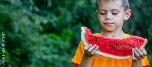 Photography Little boy eating a slice of fresh watermelon outdoors in a green garden on a sunny day