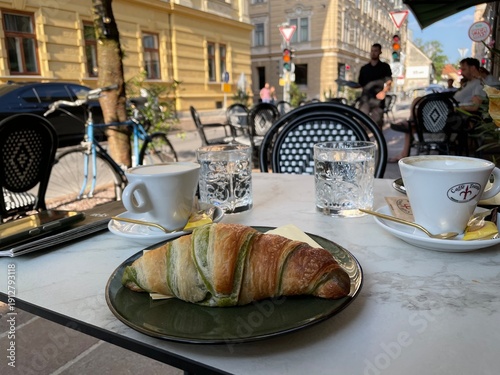 Frühstück im Café mit einem Pistaziencroissant in Ljubljana, Slowenien