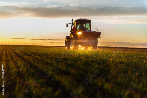 Tractor spreading artificial fertilizers in field