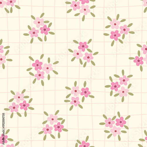 Adorable seamless pattern with small pink flower clusters with green leaves on a cream grid background. Perfect for textiles. Vector illustration.
