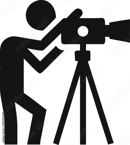 Professional videographer operates a large video camera mounted on a sturdy tripod