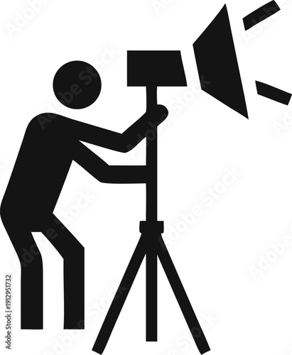 Professional Studio Lighting Arrangement with a Person Adjusting a Conical Reflector Light on a Tripod Stand