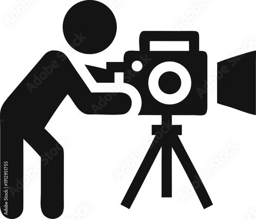 A person operates a professional video camera mounted on a tripod for recording events