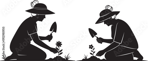 Silhouette of two people planting flowers in garden