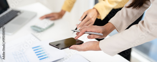 Schilderij op canvas Close up hands of Young  businesswoman showing business data on her phone to  colleague, share news, learn new AI app
