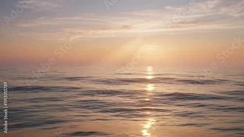 Peaceful Ocean Sunrise With Soft Golden Light Rays Breaking Through Clouds Over Calm Water Reflecting Warm Hues Of Orange And Pink In A Serene Natural Landscape