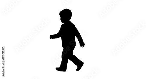A young child walking alone in a studio, captured in silhouette from a side view