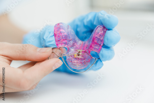 Photos Orthodontist hand in blue glove using special key to adjust expansion screw on p