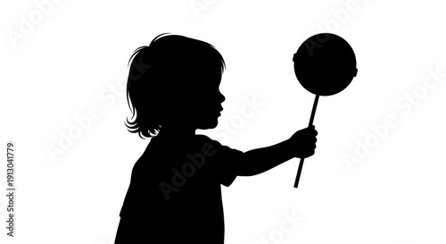 Silhouette of Child Holding Lollipop on Stick.