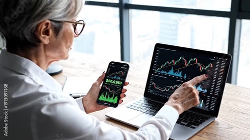 Investor Analyzing Stock Charts on Phone and Laptop