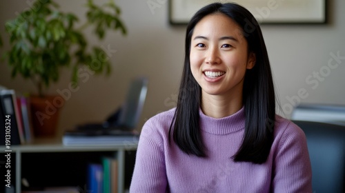 A woman is sitting in a chair with a purple sweater on. She is smiling and looking at the camera Free Download A woman is sitting in a chair with a purple sweater on. She is smiling and looking at the camera - GFXLoad