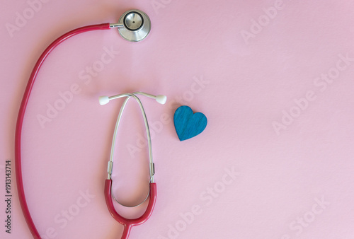Stethoscope with heart on the pink background, top view. Space for text