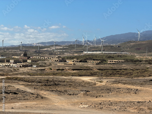 Costa árida de Tenerife con aerogeneradores y el Teide al fondo