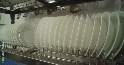 Clean White Plates Drying in Commercial Kitchen Dish Rack
