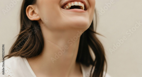 Woman laughing with open mouth against plain background