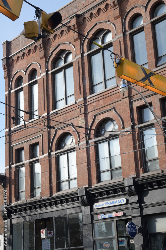 Fototapeta premium exterior building facade and sign of St. Mary Pharmacy located at 796 Queen St E, Toronto (known as Poulton Block, once Orient Hall Masonic Lodge, 1886)