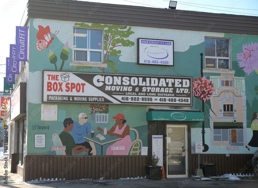 Fototapeta premium exterior building wall with mural by Andrea Manica and signs of The Box Spot, a moving supply store, located at 542 Mt Pleasant Rd, Toronto