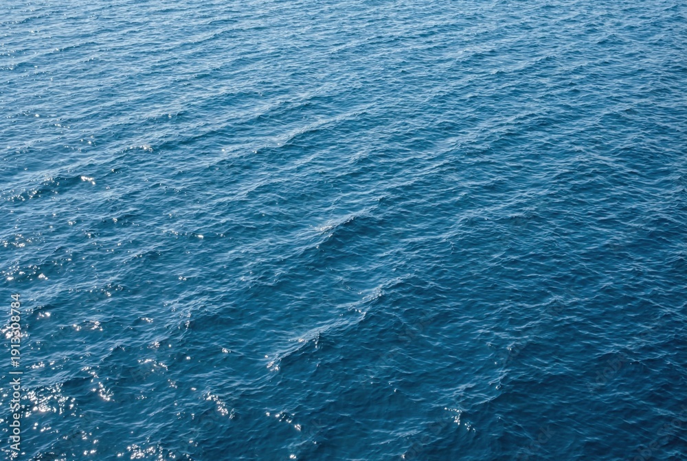 Obraz premium Deep blue ocean water surface with gentle ripples and sunlight reflections