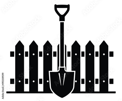 A shovel leaning on a wooden picket fence