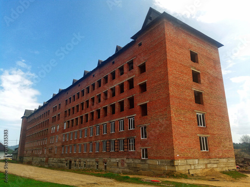 Large multi-story red brick residential building under construction