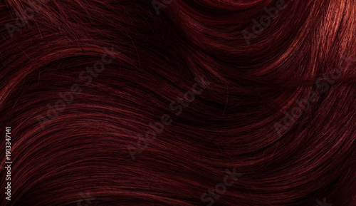 Dark red hair close-up as a background. Women's long brown hair. Beautifully styled wavy shiny curls. Coloring hair with bright shades. Hairdressing procedures, extension.