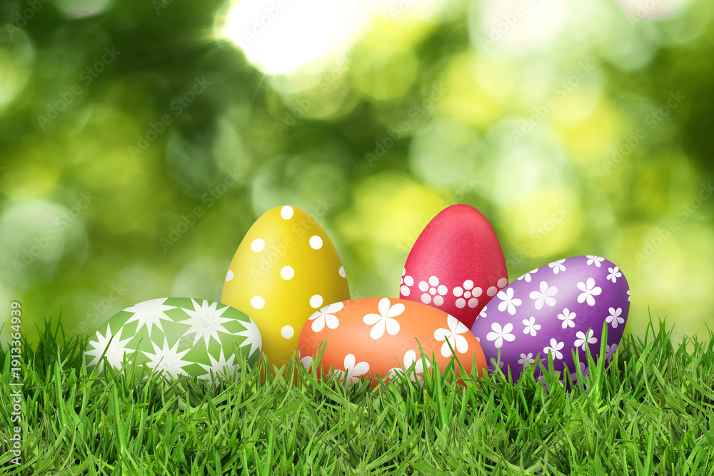Fototapeta premium Easter eggs in green grass against blurred background