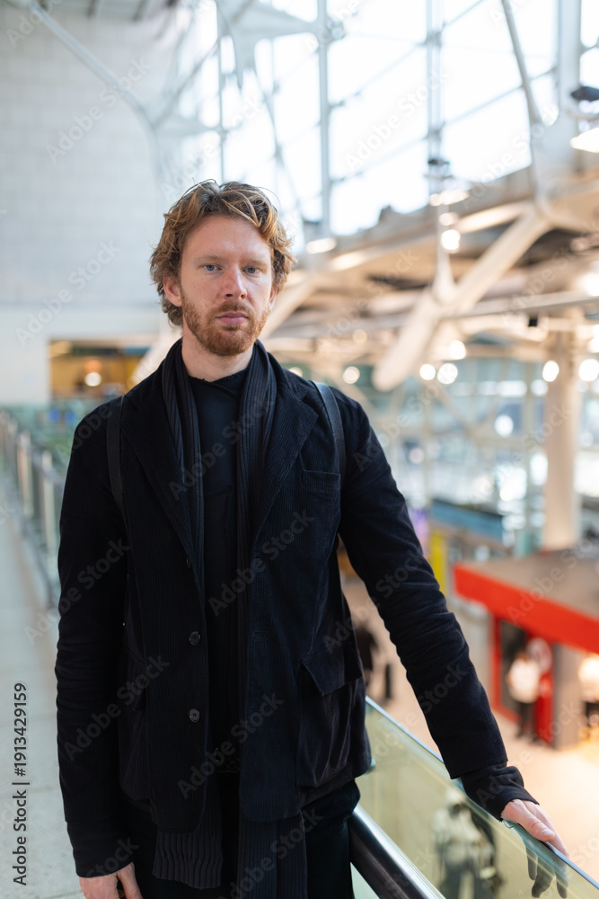 Obraz premium Man standing in modern transportation hub looking at camera