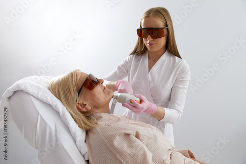 Foto Woman receiving laser treatment in modern cosmetology clinic