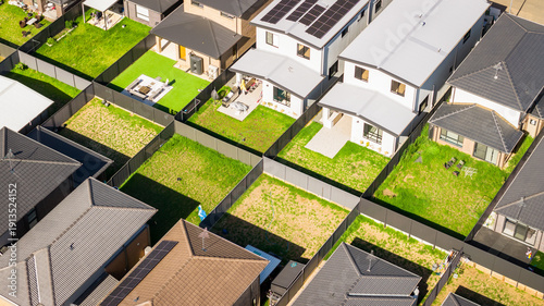 Aerial View of Modern Suburban Homes with Fenced Backyards and Solar Panels