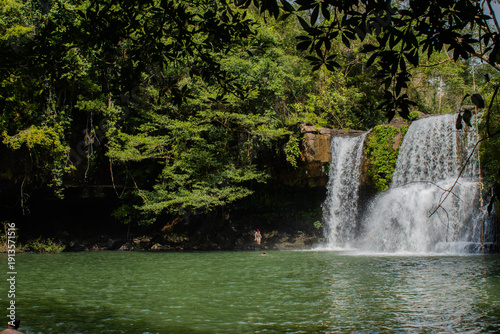 Beautiful Khlong Chao waterfall flowing into natural lagoon on Koh Kood, Thailand. Tropical forest scenery, exotic travel location, adventure and eco tourism concept with lush greenery.